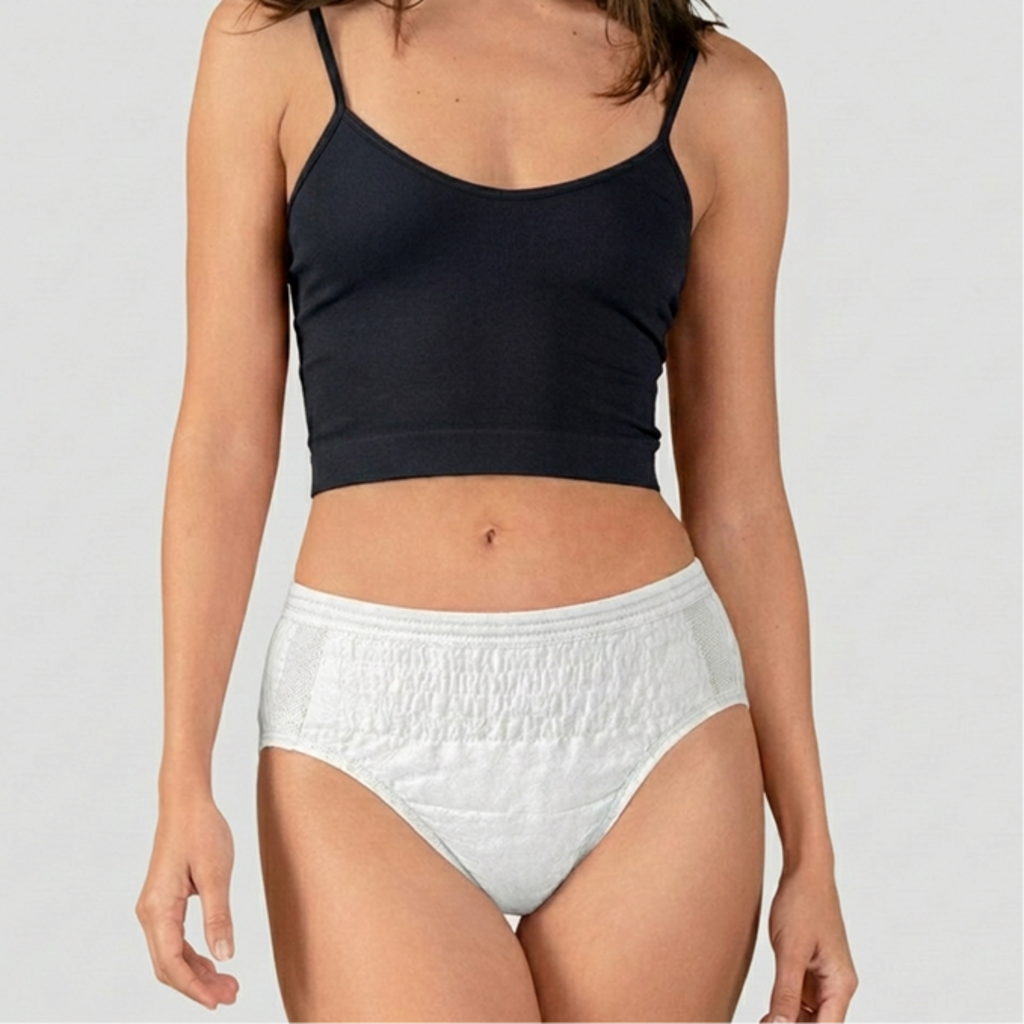 Person wearing a black crop top and white high-waisted underwear on a plain background