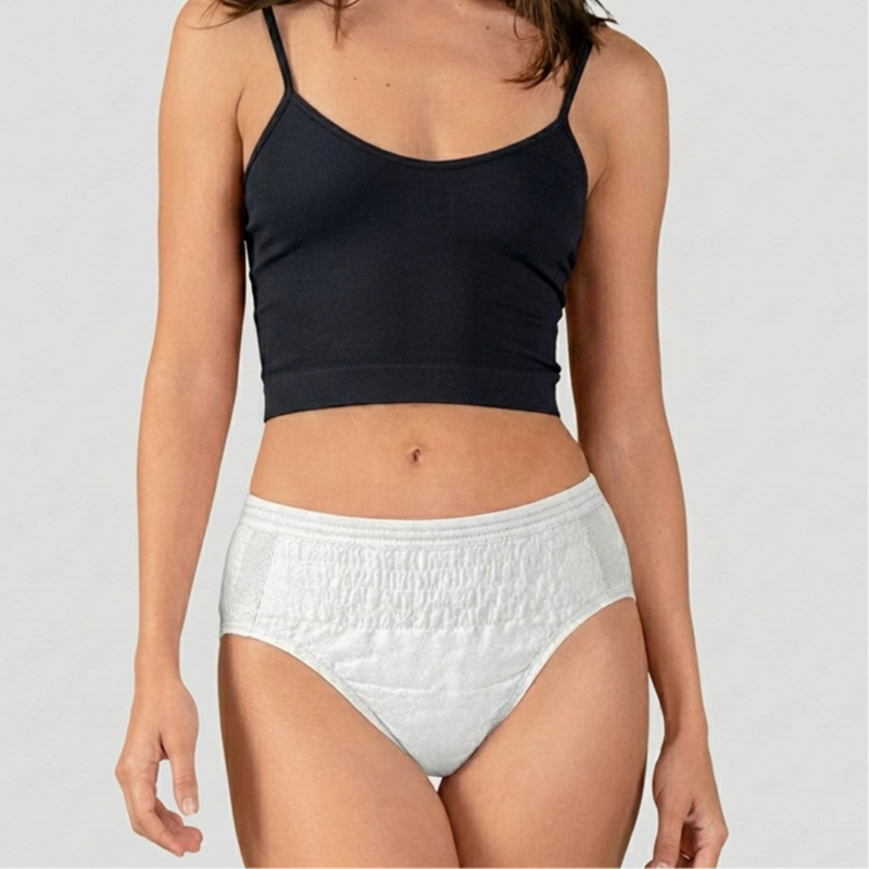 Person wearing a black crop top and white high-waisted underwear on a plain background